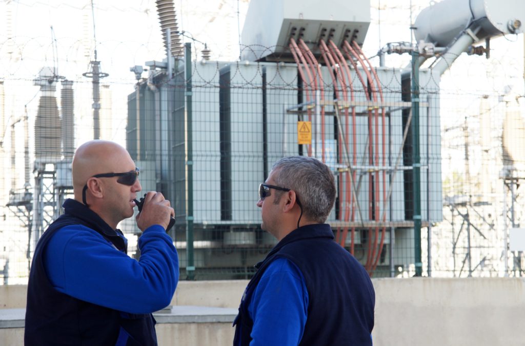 two men guarding industrial building and talking on walkie talkie